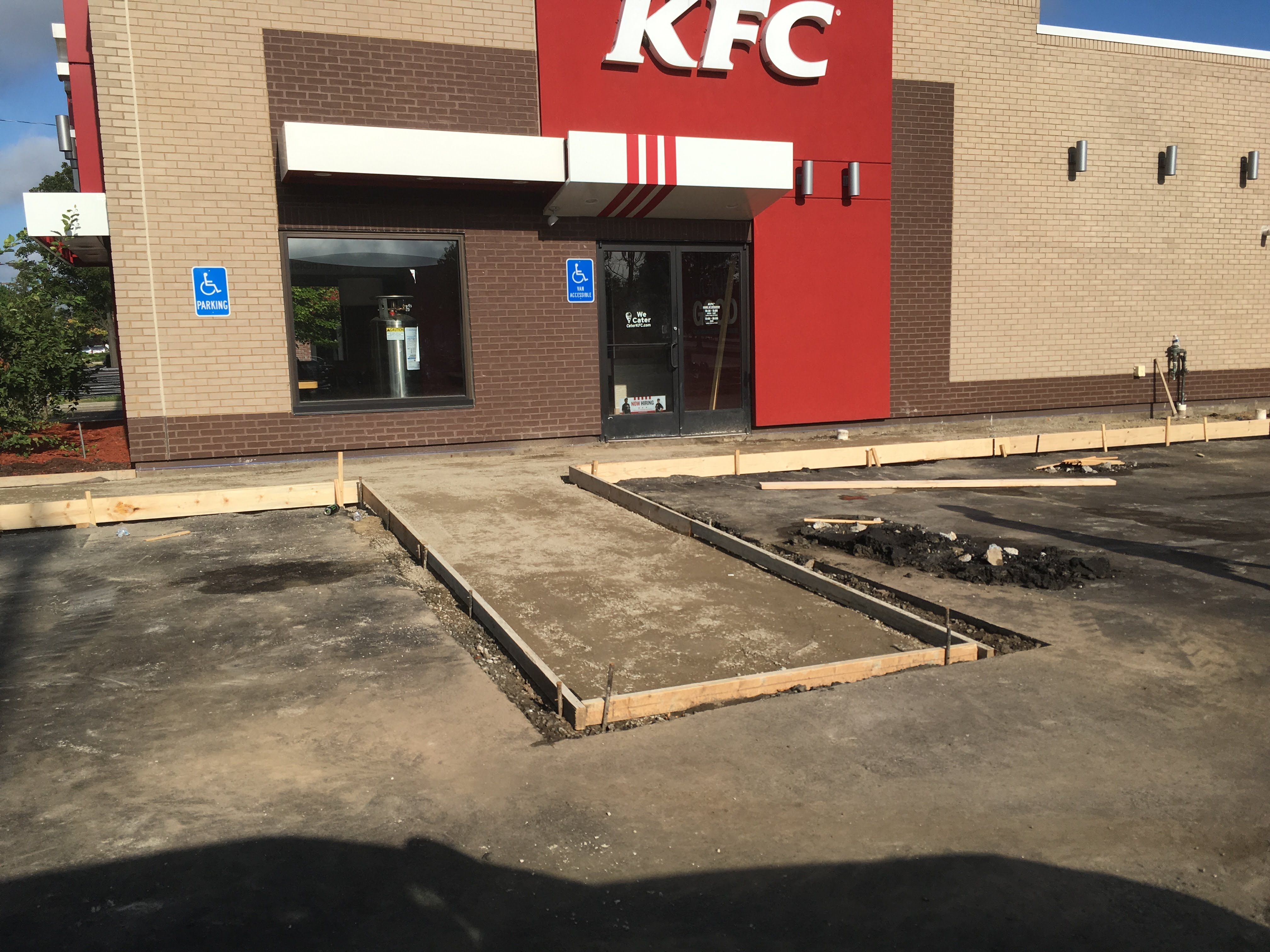 Before condition at restaurant parking lot with aged pavement and striping wear